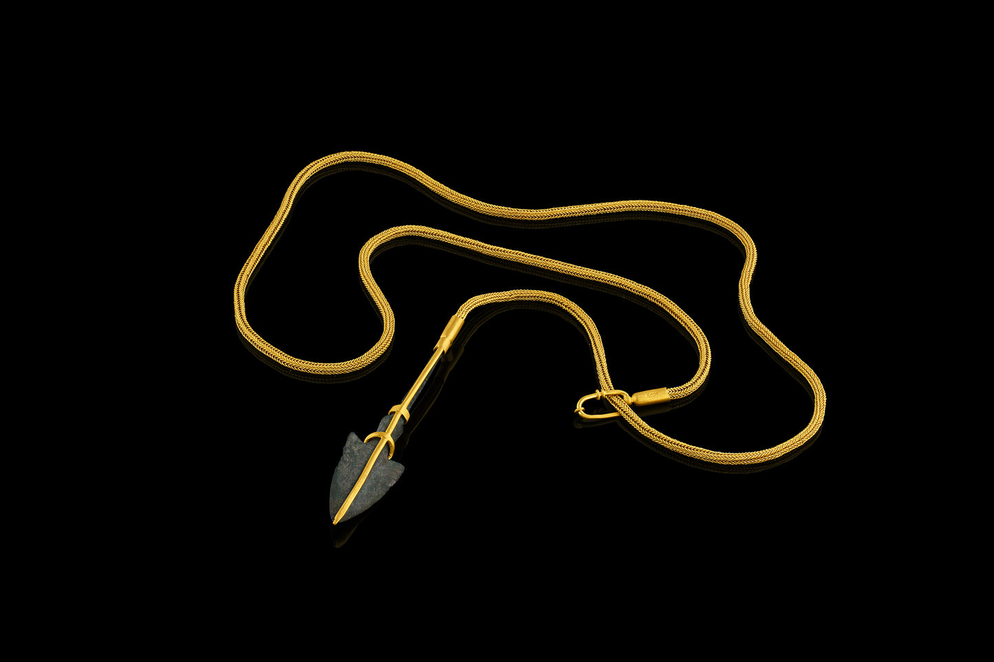 Persian bronze arrowhead (c. 1200-1800 BCE) in a modern gold frame accented with diamonds on a handwoven gold chain.