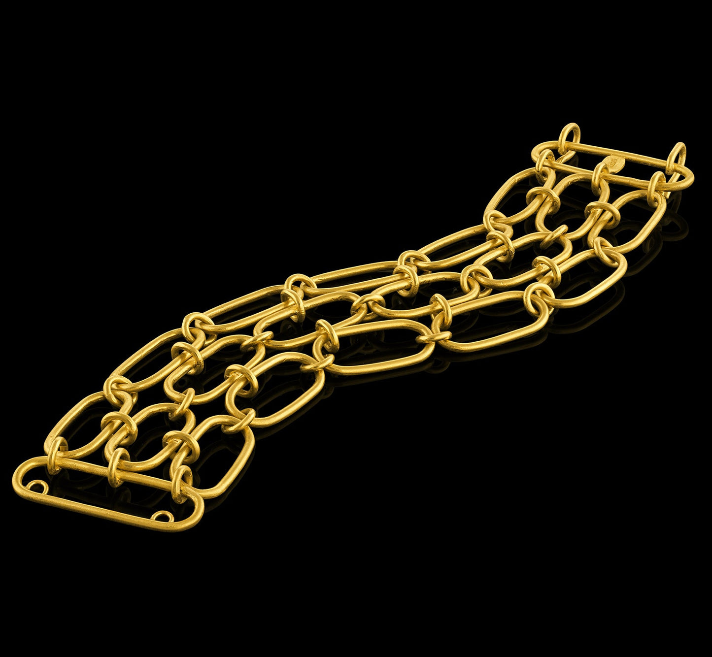 A handmade 22-karat gold chain bracelet composed of three lines of oval links interconnected by smaller links.