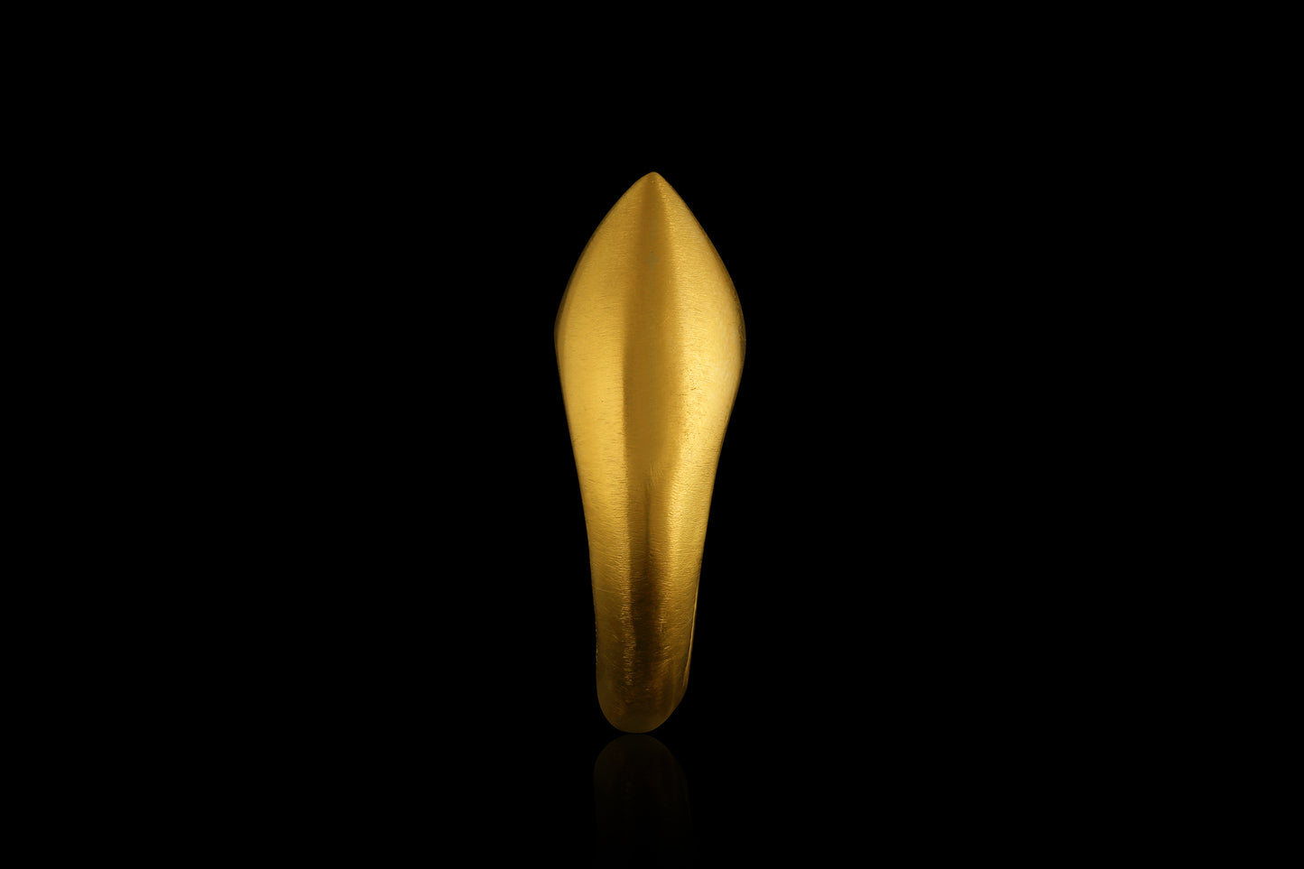 A hollow gold point ring, raise by hand, inspired by the ancient design of archer's rings. Profile view.