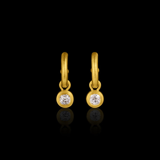 Gold earrings with antique diamonds on a black background