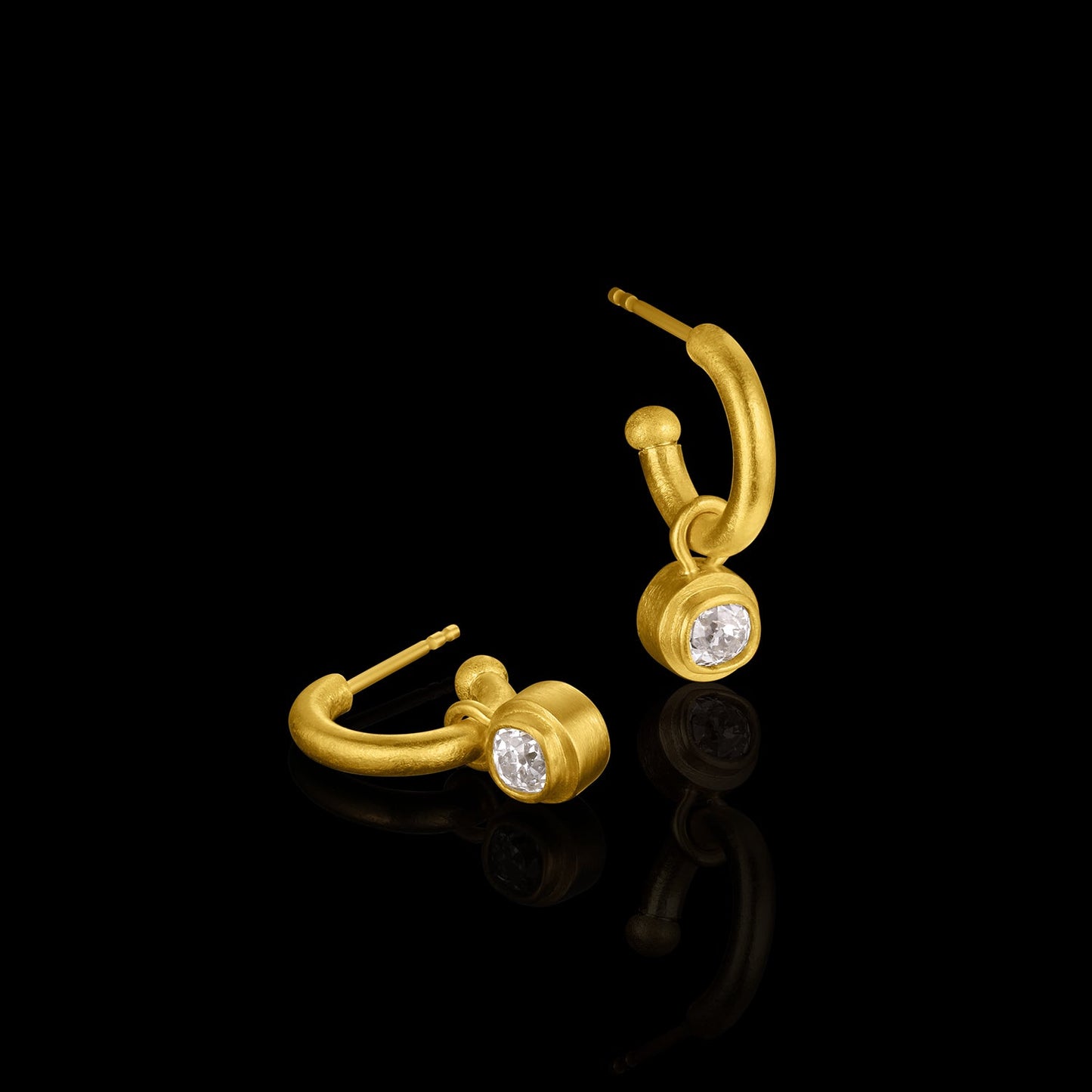 Gold earrings with antique diamonds on a black background