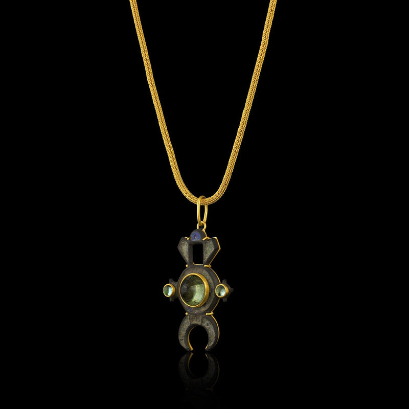 Ancient Roman Bronze Lunula brooch (c. 200 CE), centering a green tourmaline, accented with blue-green tourmaline, in a modern gold frame. Hanging from handwoven chain.