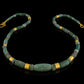 Iranian turquoise bead and gold necklace on leather.
