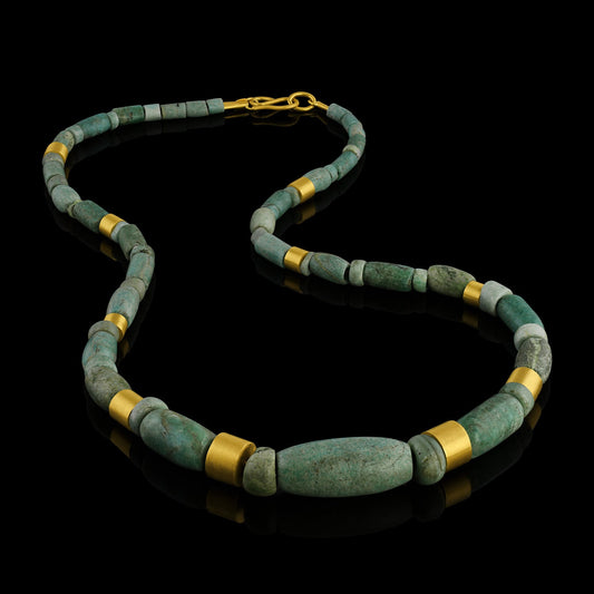 Iranian turquoise bead and gold necklace on leather.