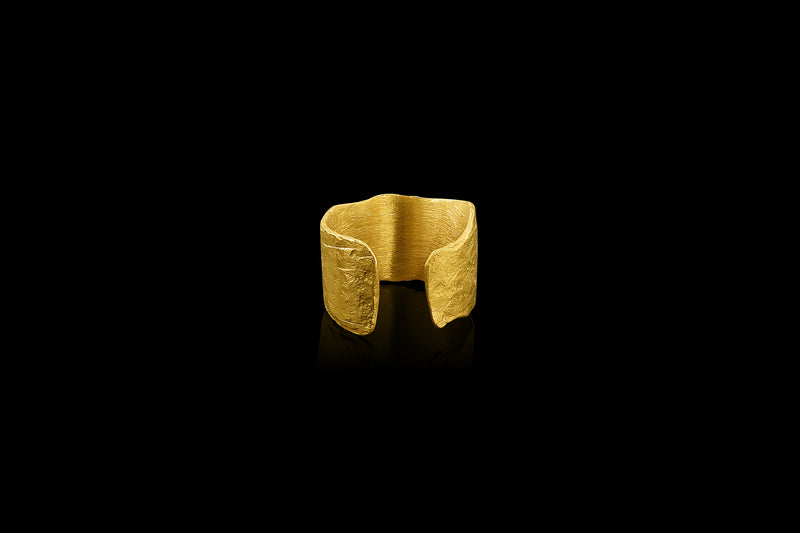 An ear cuff formed from a hammered sheet of gold with an organic edge inspired by papyrus, the reed paper used by the ancient Egyptians.