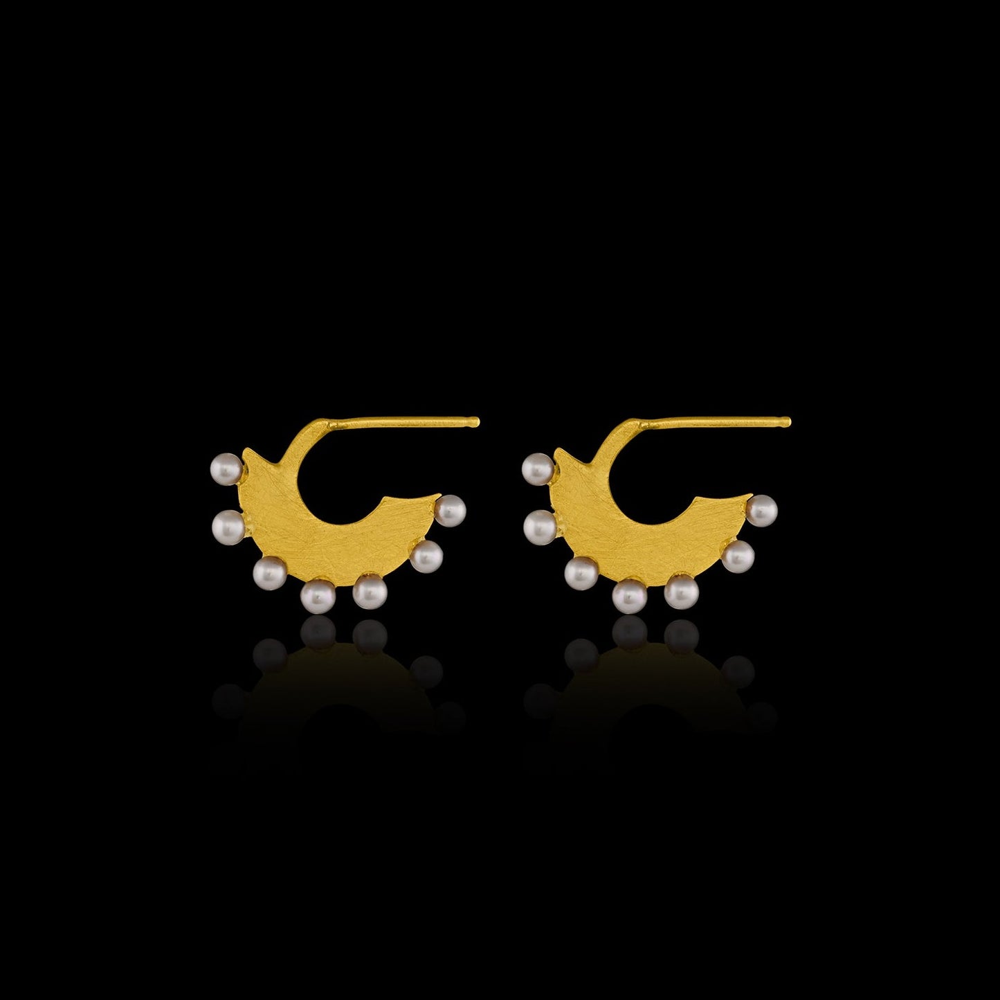 Flat gold huggie hoop earring with seven white pearls along the edge.  Side view. 