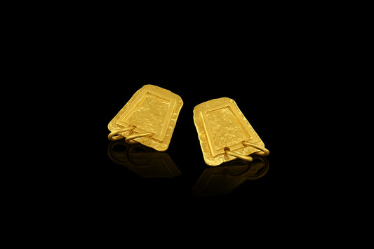 Earrings based on the shape of ancient tablets, featuring a textured surface and suspending two hoops.  