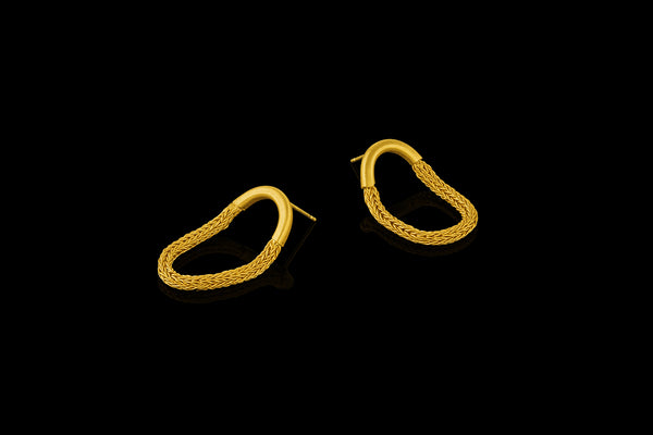 Earrings featuring a woven chain suspended from a gold tube.  - angled