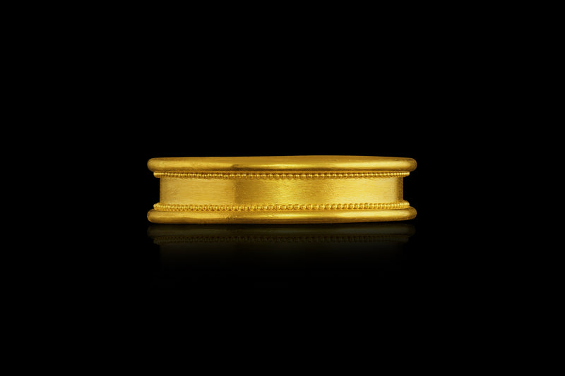 A 22k gold band with cylindrical edges and two lines of hand-placed granules. 
