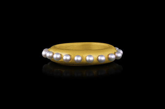 A 22k gold band ring accented with Akoya pearl spheres - Side view