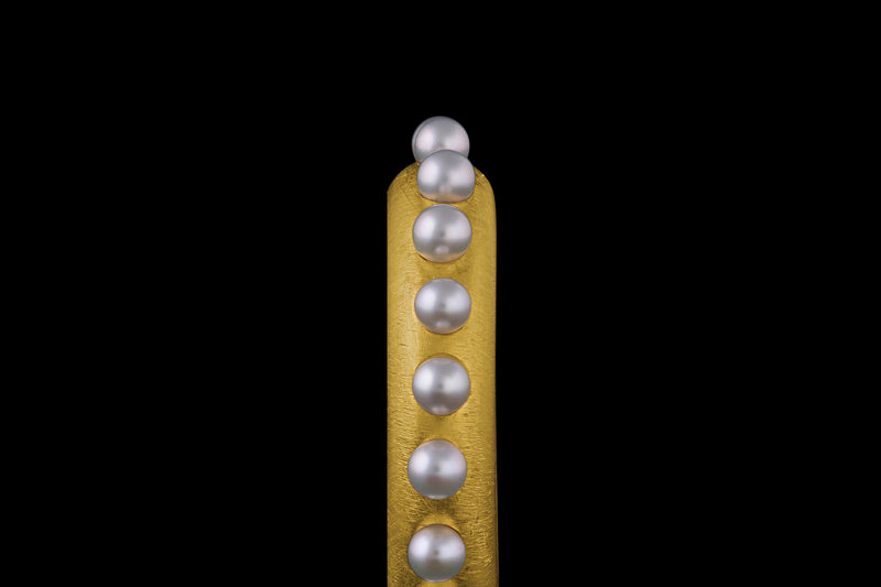 A 22k gold band ring accented with Akoya pearl spheres - Angled view