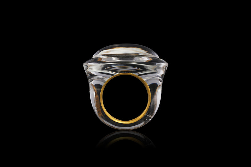 A velvet gold band sits inside a handcut polish rock crystal ring. Inspired by ancient Greecian design, this solid quartz ring has volume and layers - side