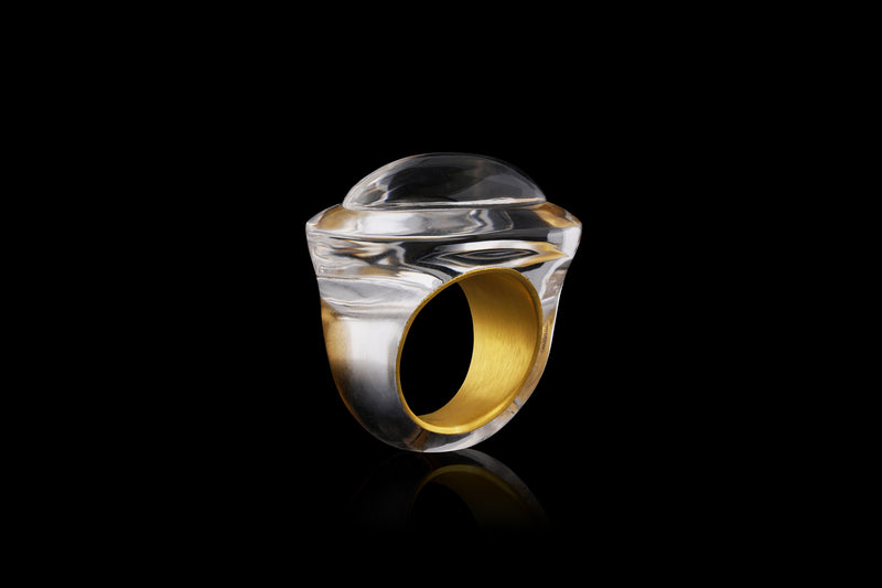 A velvet gold band sits inside a handcut polish rock crystal ring. Inspired by ancient Greecian design, this solid quartz ring has volume and layers - angled