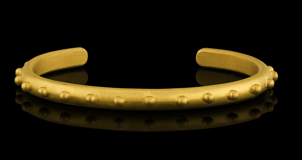 A playful 22-karat gold cuff bracelet accented with spheres of gold.